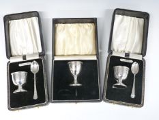 Three cased hallmarked silver egg cups, two having spoons, weight 116g