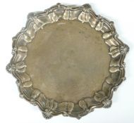 Edward VII hallmarked silver salver with shaped edge and raised on three feet, Sheffield 1909, maker