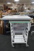 A metal medical trolley with two plastic trays and adjustable shelf and wire mesh basket