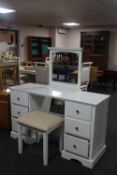A contemporary white dressing table fitted with six drawers together with a dressing table stool