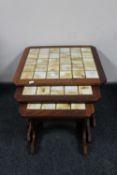 A nest of three twentieth century teak tiled tables
