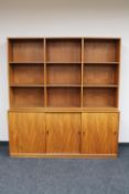 A mid century teak bookshelf fitted with triple door cupboard CONDITION REPORT: