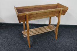 A teak plant trough with under shelf