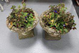 A pair of weathered concrete garden planters