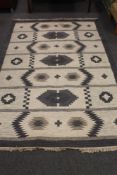 A fringed woollen rug of geometric design