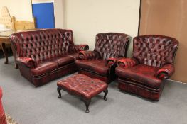 A four piece red button leather Chesterfield lounge suite comprising three seater settee,