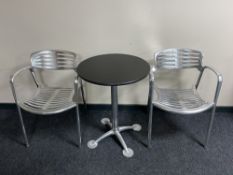 A circular granite topped table on metal four-way pedestal and a pair of Jorge Pensi designed