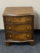 A Reprodux serpentine fronted three drawer chest