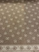 A large fringed brown and cream carpet