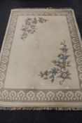 A cream fringed floral embossed Indian carpet