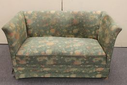A 1930's two seater settee in green floral fabric