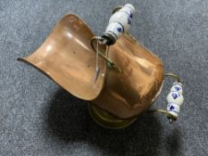 An early 20th century copper and brass coal helmet with porcelain handle