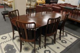 A mahogany extending dining table with two leaves and six rail back chairs