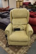 An electric reclining armchair in sand coloured fabric