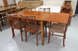 A mid 20th century extending dining table and five rail back chairs