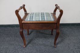 An Edwardian oak storage piano stool
