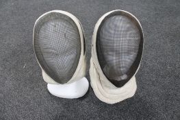 Two fencing masks on polystyrene heads