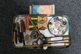 A tray of two antique brass temperature gauges, enamelled transport badges, two pocket watches,