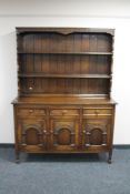 A carved oak triple door kitchen dresser