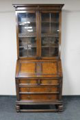 An early 20th century carved oak bureau bookcase with plaque '1879-1929, Presented to Mr. William I.