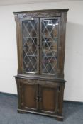 A carved oak leaded door corner cabinet