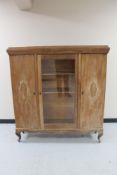 A 20th century stripped oak triple door cabinet