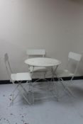 A circular metal patio table and three folding chairs