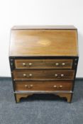 A Victorian inlaid mahogany writing bureau fitted with three drawers