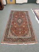 A Kashan rug, on red ground,