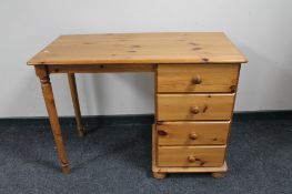 A pine kneehole desk fitted with four drawers