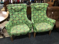 A pair of high backed armchairs in fern print