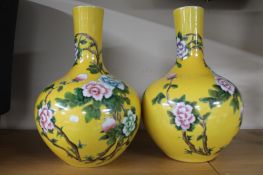 A pair of glazed ceramic bulbous Chinese style vases with pink flowers,