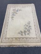 A cream fringed floral embossed Indian carpet