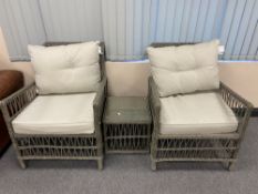 A pair of wicker conservatory armchairs and glass topped table