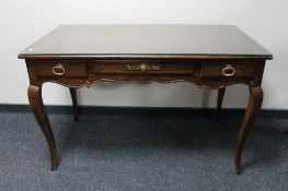 An American-style three-drawer writing desk, on cabriole legs.