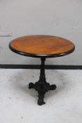 A circular topped pub table on cast iron tripod base.