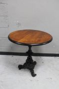 A circular topped pub table on cast iron tripod base.