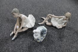 Two Nao figures of ballerinas together with another Nao figure of two puppies in a basket