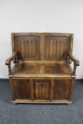 A 20th century oak linen fold monk's bench