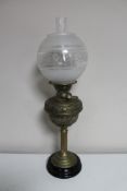 A brass oil lamp with etched glass shade