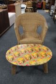 An oversized wicker armchair and a teak coffee table with Marilyn Monroe themed top
