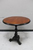A circular topped pub table on cast iron tripod base.