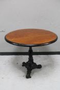 A circular topped pub table on cast iron tripod base.