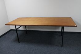 A 1970's teak dining table on metal legs.