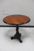 A circular topped pub table on cast iron tripod base.