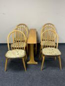 An Ercol elm narrow drop leaf table and six dining chairs.