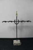 A cast metal horse shoe boot stand on concrete base