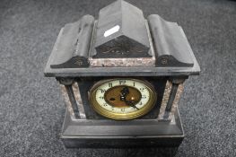 An antique black slate and marble mantle clock with brass and enamel dial
