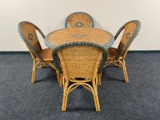 A circular bamboo and wicker dining table together with four chairs