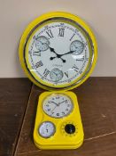 Two yellow enamel wall clocks